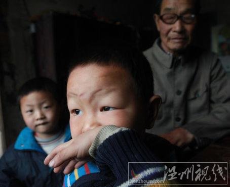 毛坪村的小男孩袁石(中)，告訴記者，他的妹妹袁麗一歲的時候，被搶走了，至今下落不明。他想念妹妹，多次夢到她回家了。 記者 李漠 攝